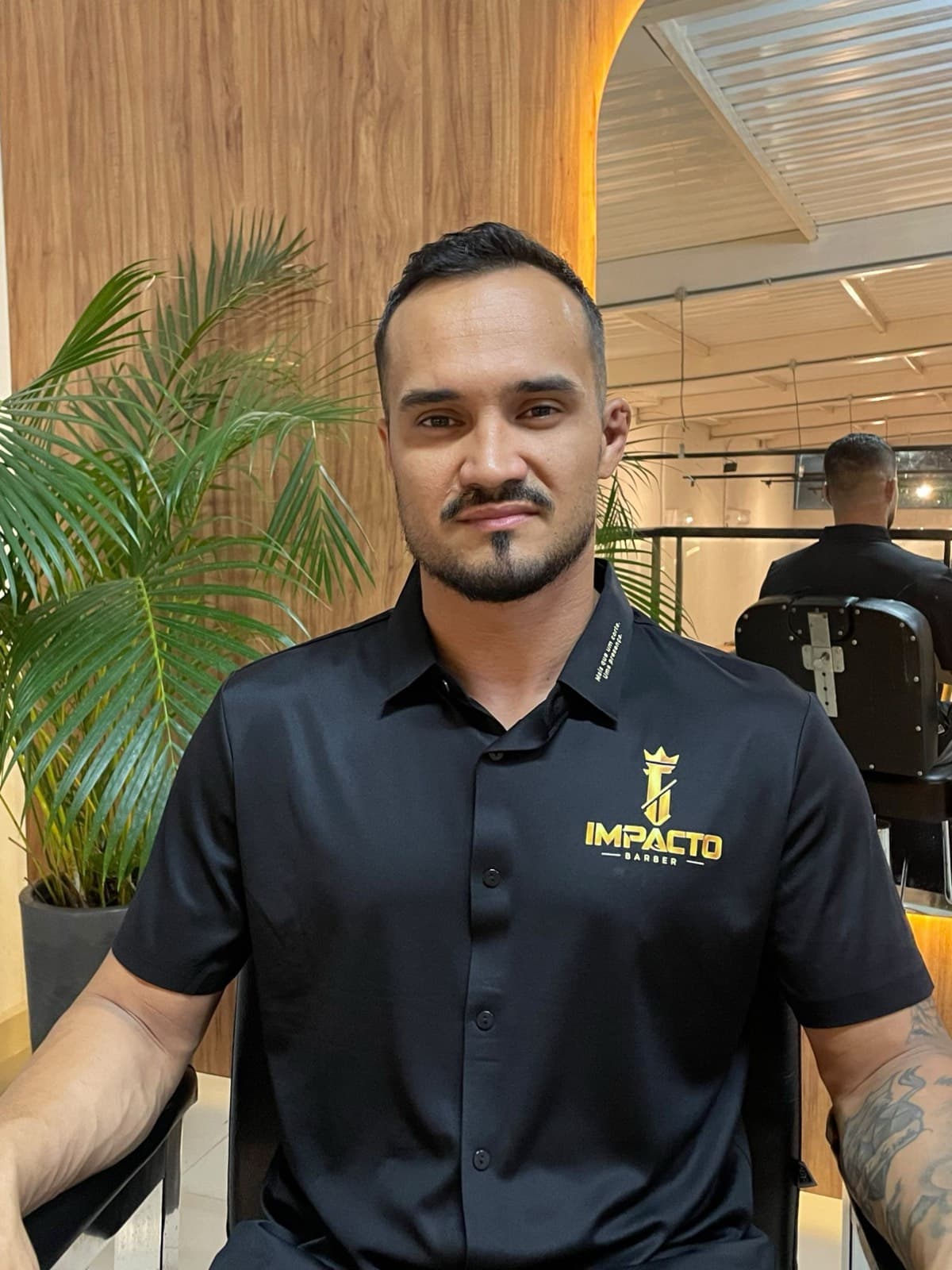 Carlos Eduardo, o Dudu, com o uniforme da Impacto na barbearia